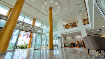 Un hall espacioso con techos altos, puertas de cristal amplias y un diseño moderno.