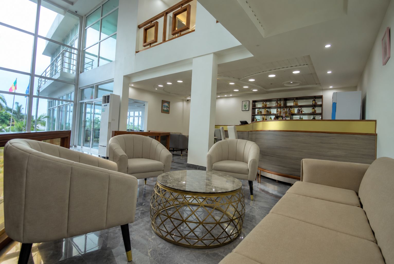 A spacious lobby with a reception desk, seating area, and large windows.