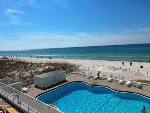 Una piscina junto a una playa con vista despejada al océano.