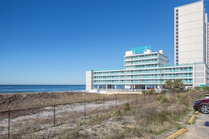 Un hotel de varios pisos con terraza y vistas al océano.