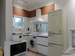 Una cocina moderna con lavadora integrada, microondas y refrigerador.