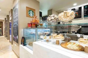 Une vitrine de boulangerie présentant diverses pâtisseries et le logo de Starbucks.