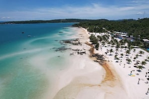 A coastal beach with clear waters, a sandy shore, and a line of palm trees. - The Beach Resort (Koh Rong island)
