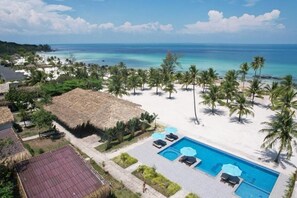 A resort with a swimming pool, palm trees, and a beach. - The Beach Resort (Koh Rong)