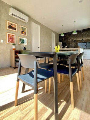 A modern dining area with a black table and chairs, an air conditioning unit, and artwork on the walls. - New Listing (Progreso)