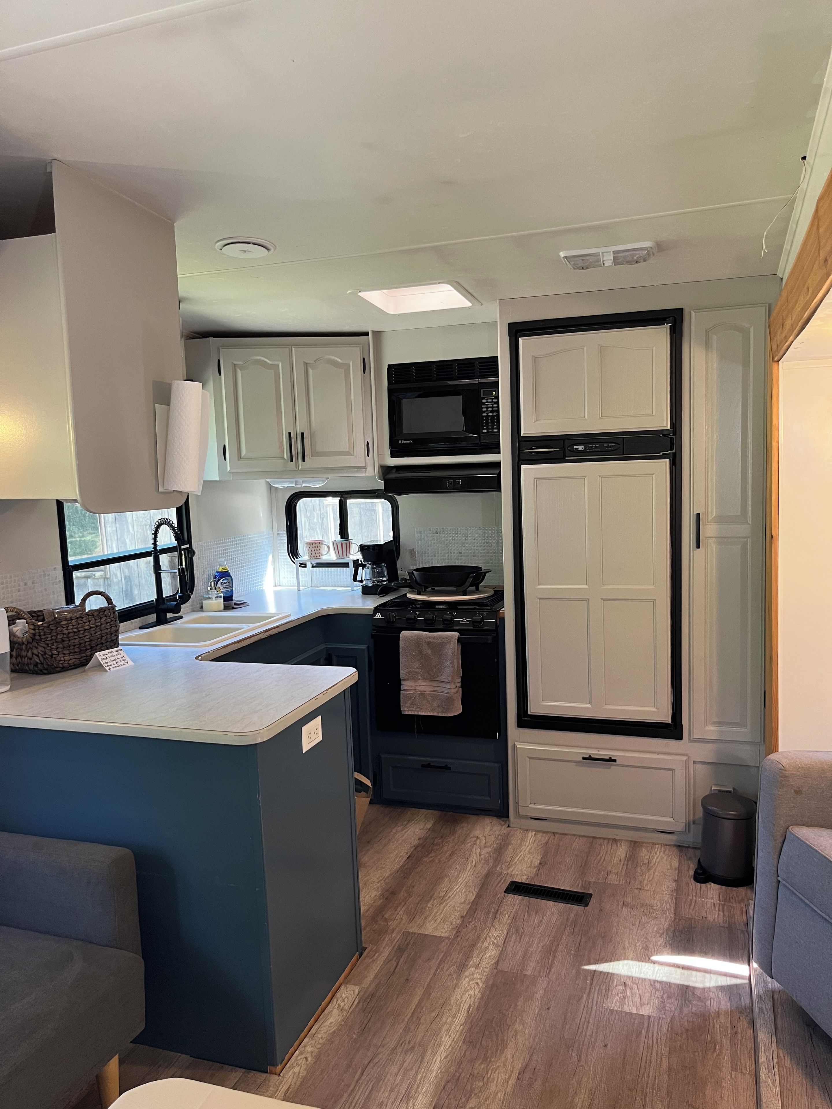 A compact kitchen with a microwave, stove, and cabinets.