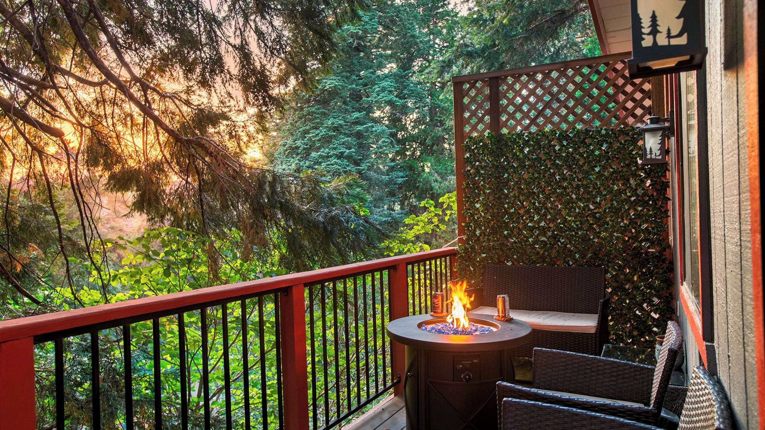 A balcony with a fire pit, outdoor furniture, and a view of a forested area.