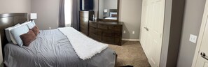 Un dormitorio con cama, cómoda y televisor.