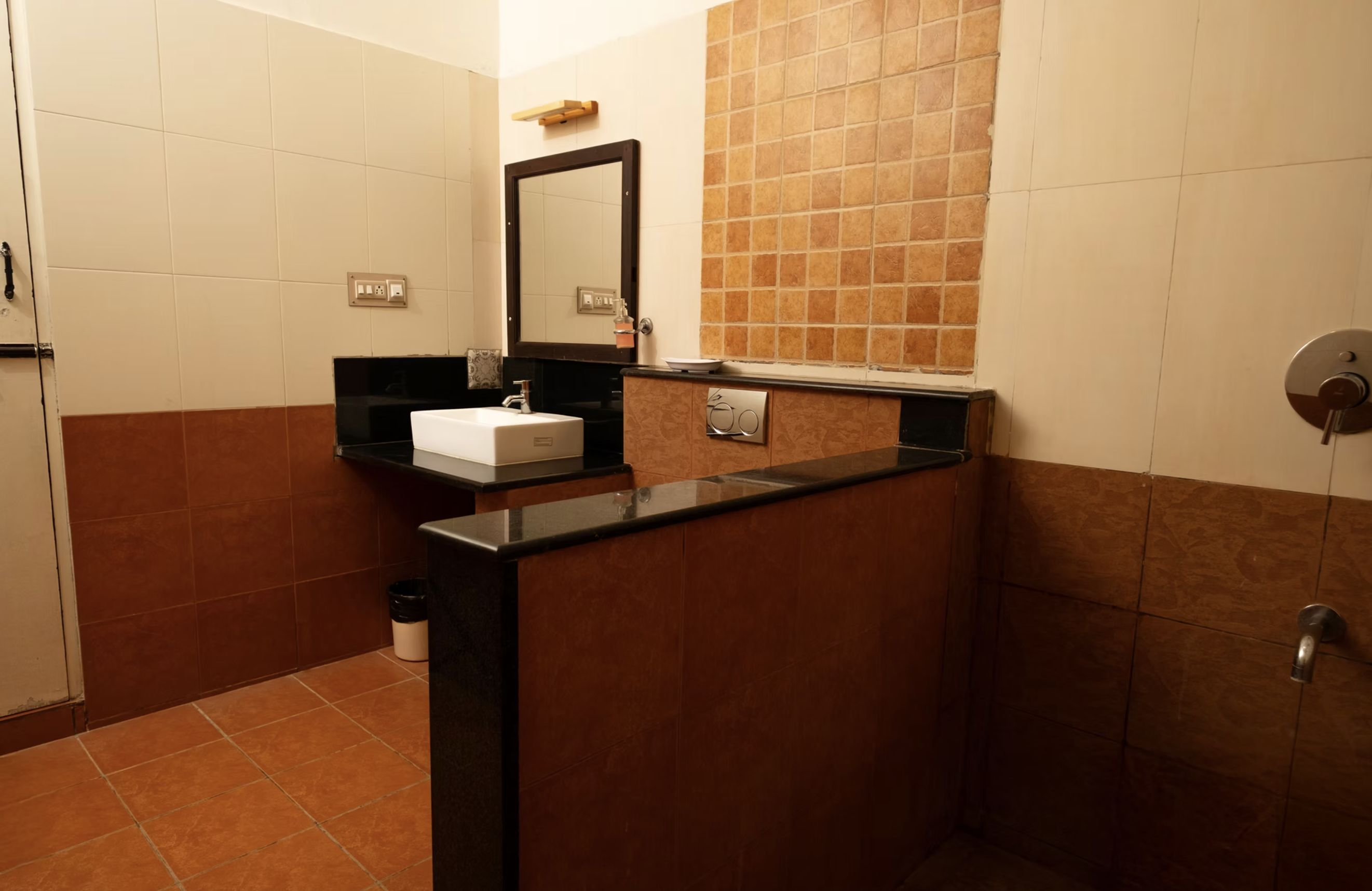 A bathroom with a black countertop, a white sink, a mirror, and a towel rack.