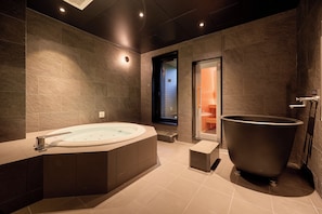 A modern bathroom with a freestanding bathtub, a large freestanding bathtub, and a walk-in shower. - Rakuten STAY VILLA Furano (Furanoshi)