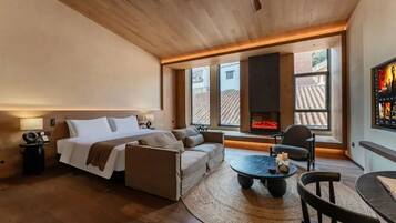 Habitació moderna amb llit, sofà i una llar de foc.