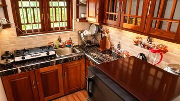 A kitchen with wooden cabinets, a gas stove, and a sink.