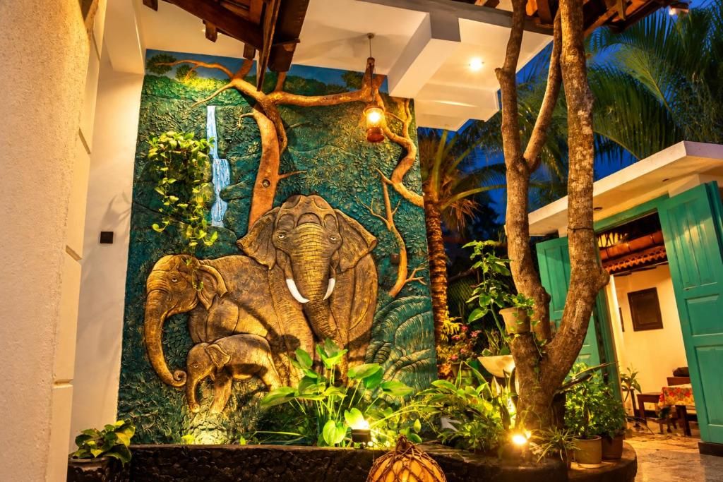 A wall mural of an elephant, a tree, and a waterfall.