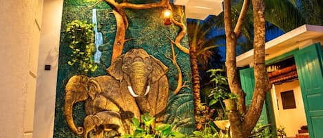 A wall mural of an elephant, a tree, and a waterfall.
