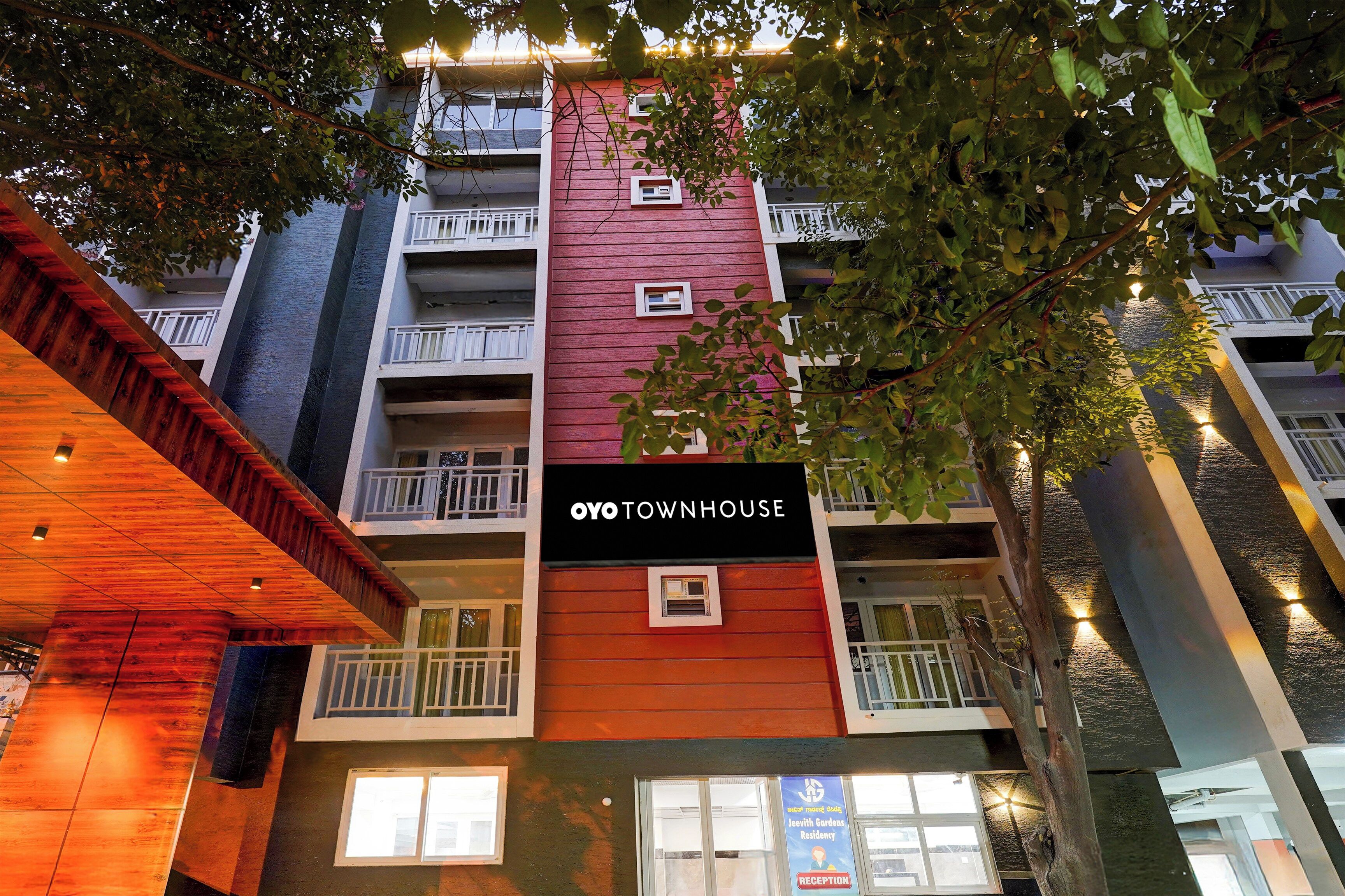 A multi-story building with balconies and a sign that reads 'OYO TOWNHOUSE.'