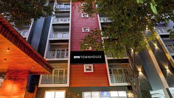 Um edifício com vários andares e varandas, com uma placa que diz 'OYO TOWNHOUSE'.