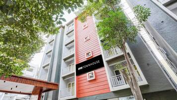 Un edificio de varios pisos con balcones y un letrero que dice 'OYO TOWNHOUSE'.
