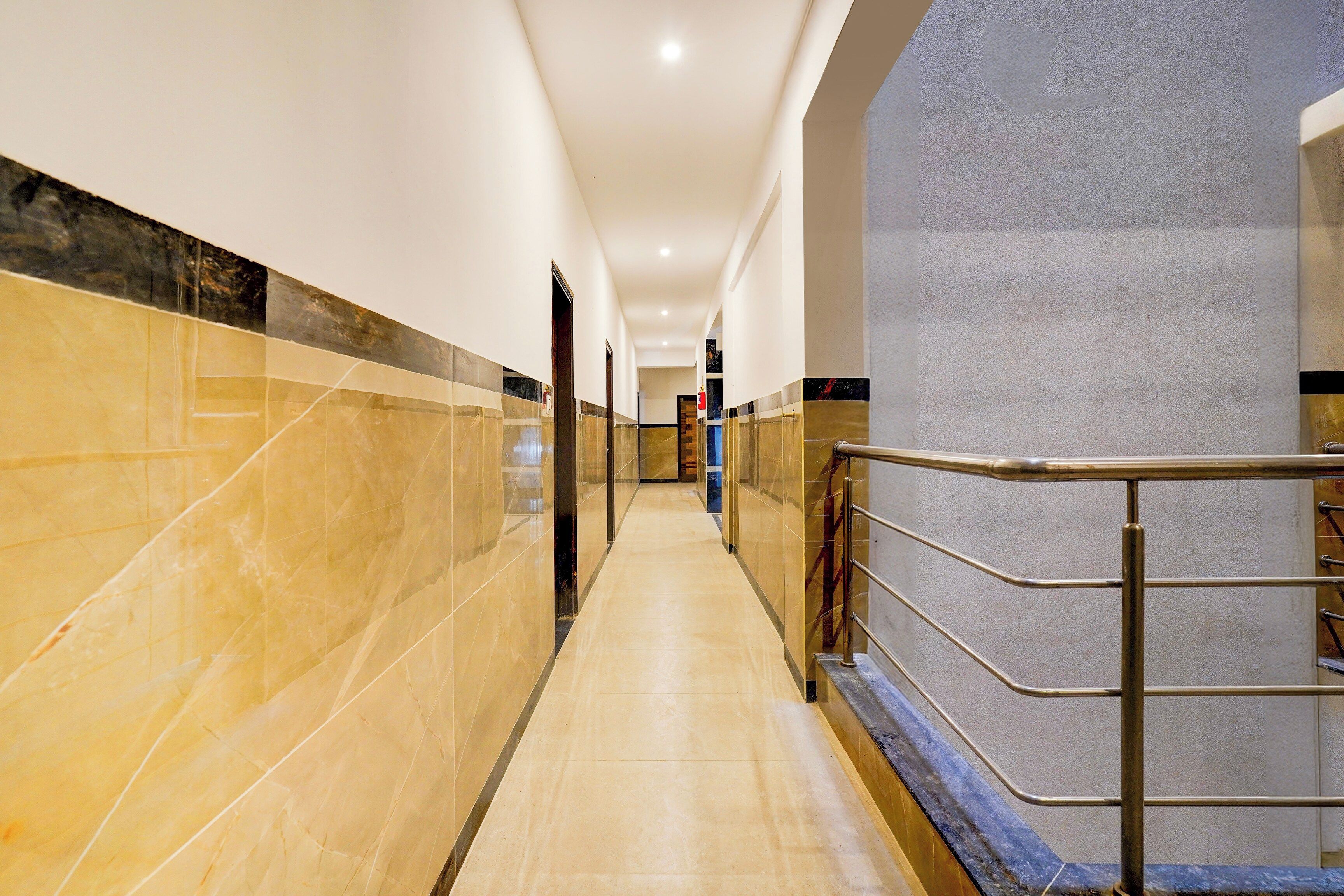 A corridor with marble walls and a metal railing.