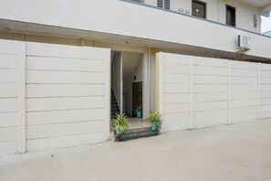 A building with a white exterior, a visible staircase leading to an upper level, and two potted plants on the ground floor. - Hotel O Aqua Comforts (Bangalore)