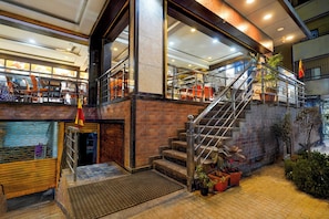 A multi-level interior with a staircase, metal railings, and a brick wall. - Power Break Townhouse Whitefield (Bangalore)