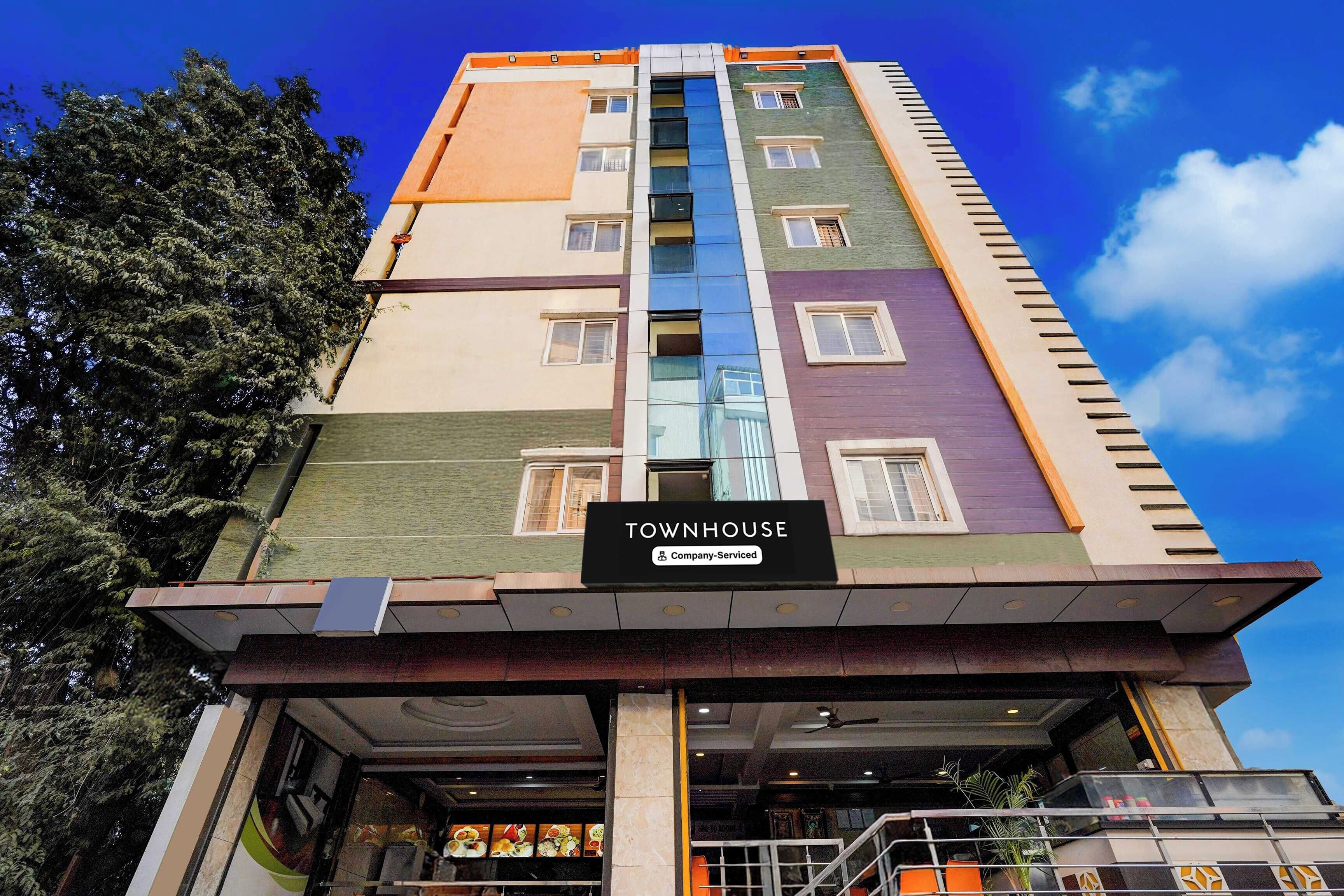 A multi-story building with a sign reading 'TOWNHOUSE' and a company-serviced label.