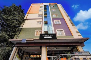 A multi-story building with a sign reading 'TOWNHOUSE' and a company-serviced label. - Power Break Townhouse Whitefield (Bangalore)
