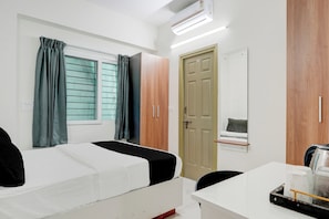 A room with two beds, a desk, a chair, a wardrobe, and a door. - Hotel O by OYO Arrow Inn (Bangalore)