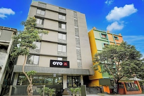 A hotel building with a sign for OYO Hotel Arrow Inn, featuring a modern facade with multiple windows and a visible entrance. - Hotel O by OYO Arrow Inn (Bangalore)