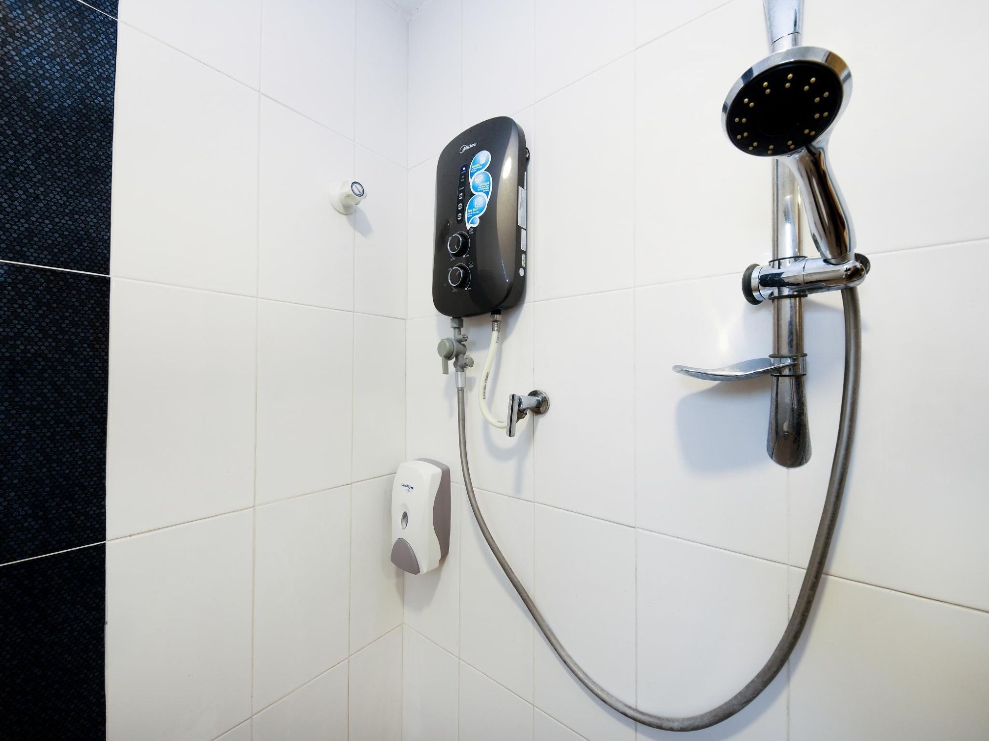 Une douche équipée d’un pommeau de douche à main et d’un panneau de commande.
