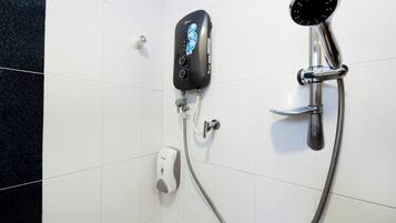 Une douche équipée d’un pommeau de douche à main et d’un panneau de commande.