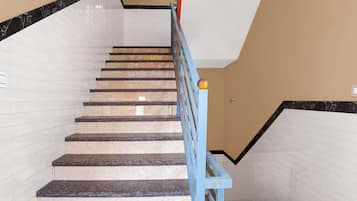 A staircase with marble steps and a blue handrail.