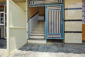 A staircase with a blue railing leading to an upper level. - HOTEL O SRI VENKATADRI ROOM (Bangalore)
