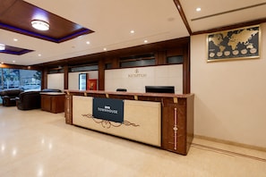 Una mesa de recepción con un letrero que dice 'OYO TOWNHOUSE' y un letrero de 'RECEPCIÓN' encima.