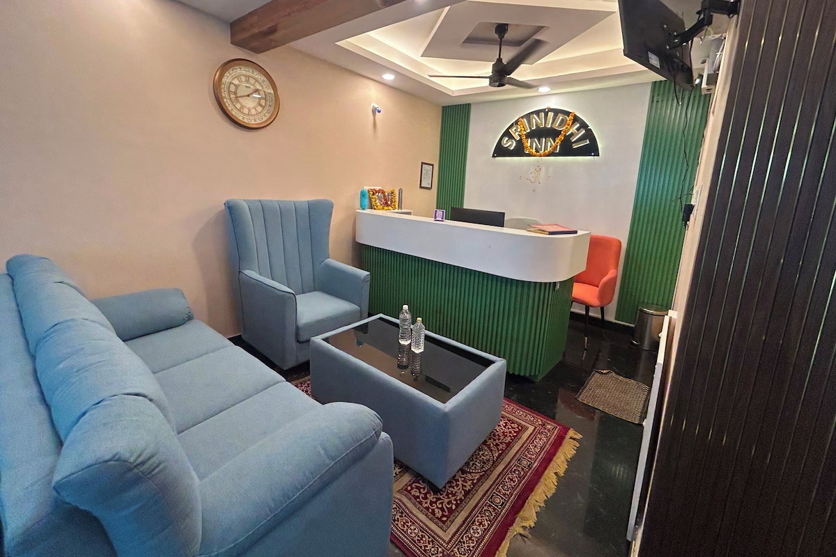 A reception area with a reception desk, a clock, and a blue armchair.
