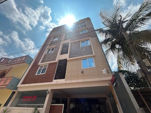 A multi-story building with a sign for 'SRINIDHI INN' and a contact number. - Hotel O Srinidhi Inn (Bangalore)