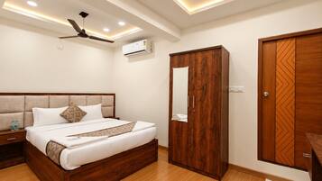Un dormitorio con cama, armario, ventilador de techo, luces empotradas y unidad de aire acondicionado.