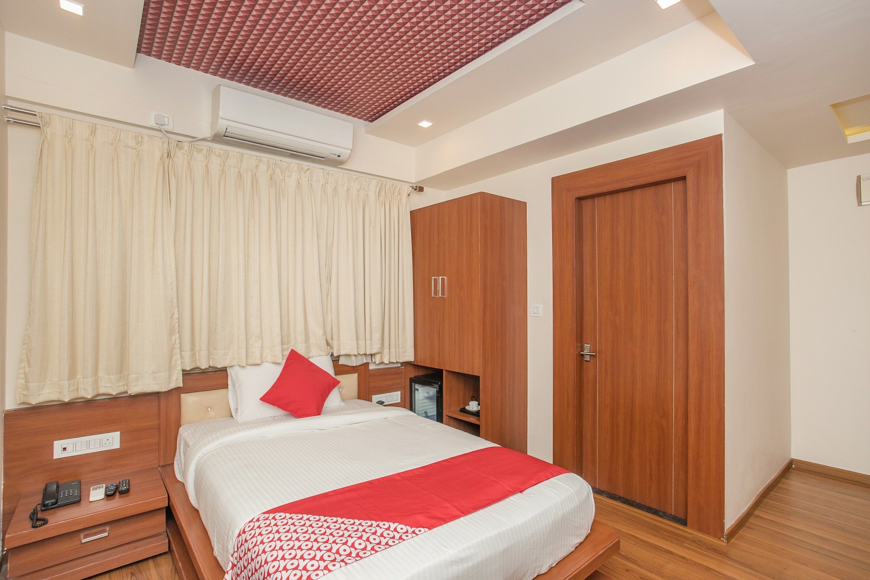 A bedroom with a bed, bedside table, and a wardrobe.