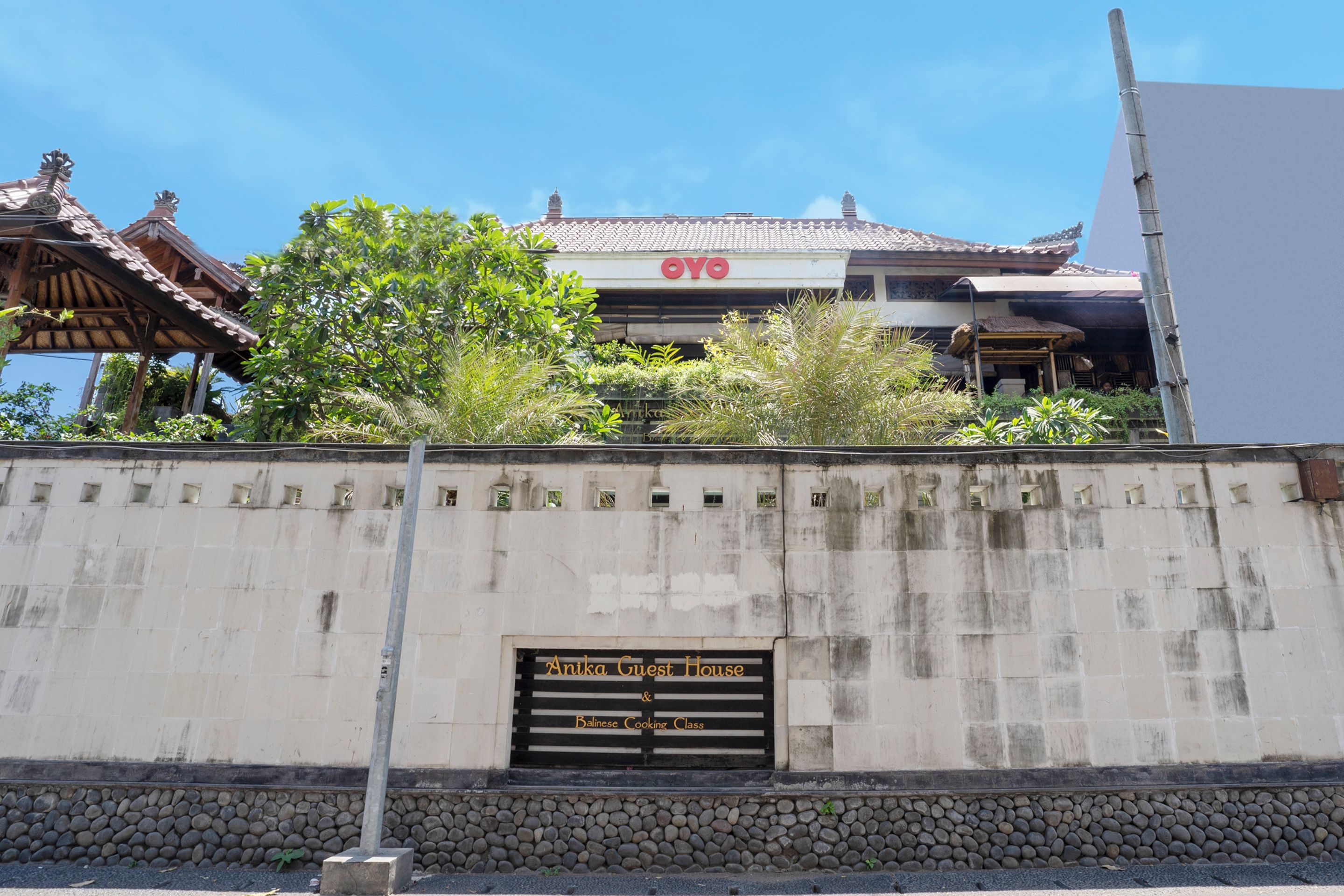 A building with a traditional roof and a sign reading "Antika Guest House."