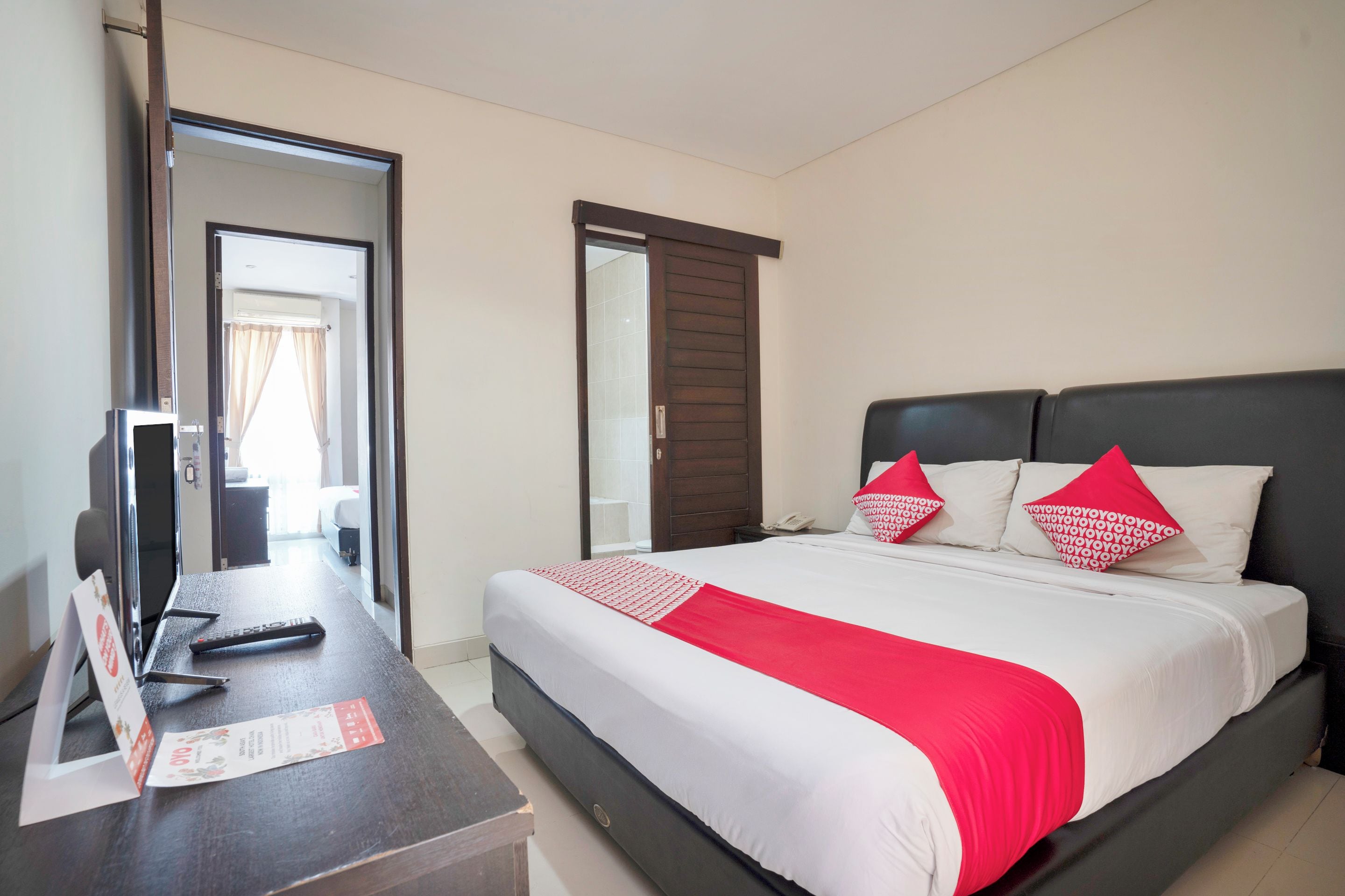 Une chambre d’hôtel avec un lit, un bureau et un miroir.