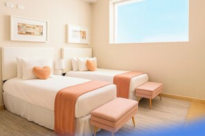 Een hotelkamer met twee bedden, een raam en kunst aan de muur.