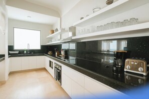 Eine moderne Küche mit weißen Schränken, einer schwarzen Arbeitsplatte und einem Retro-Toaster.