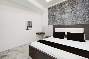 A modern bedroom with a large bed, a nightstand, and a marble floor.