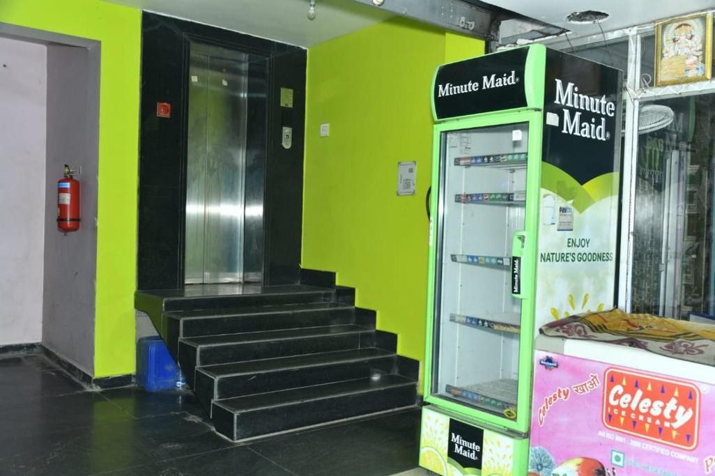 Una máquina expendedora con la marca 'Minute Maid', un extintor y una escalera con escalones negros.