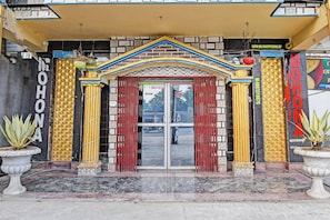 A hotel entrance with a glass door, a red curtain, and a sign for room booking. - Hotel O Mohona Residency & Restaurant (Berhampore)