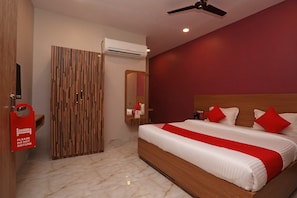 A hotel room with a bed, a wardrobe, an air conditioning unit, and a ceiling fan. - Hotel O Nirmalya Plaza (Behrampur)