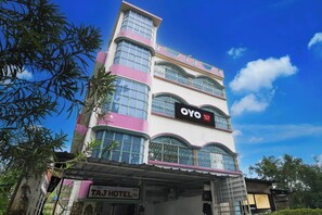A multi-story building with a sign for 'OYO New Taj Hotel' on the facade.
