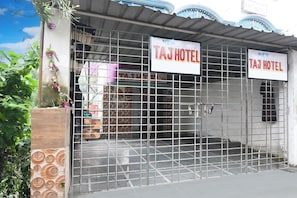 Una entrada con reja a un edificio que muestra un letrero con la leyenda 'TAJ HOTEL'.