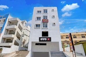 A multi-story building with a sign for 'VIRAJ Luxury Stay' indicating premium rooms. - Hotel O Viraj Luxury Stay (Warangal)