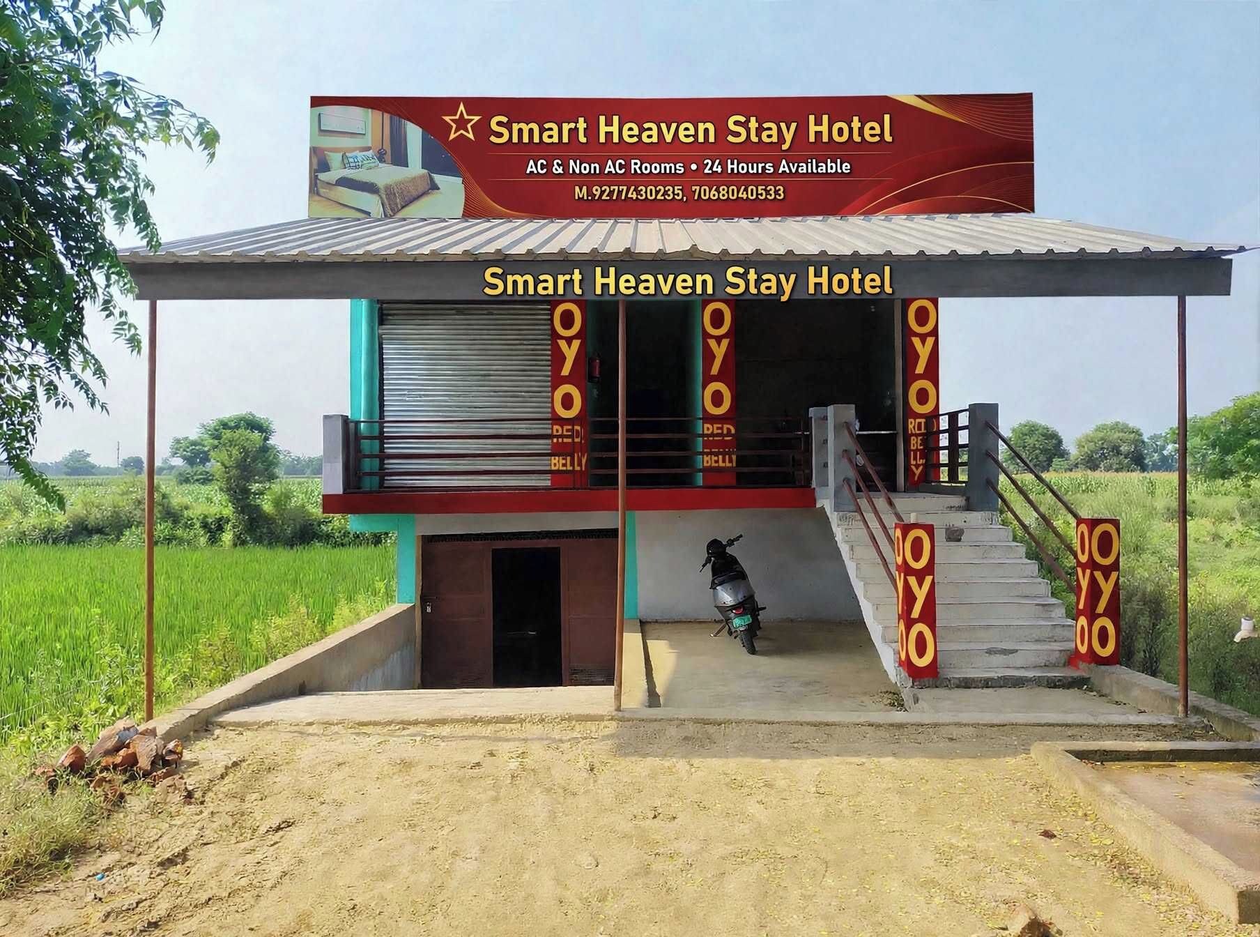 A two-story building with a signboard for Smart Heaven Stay Hotel, featuring AC & Non AC rooms and 24-hour availability.