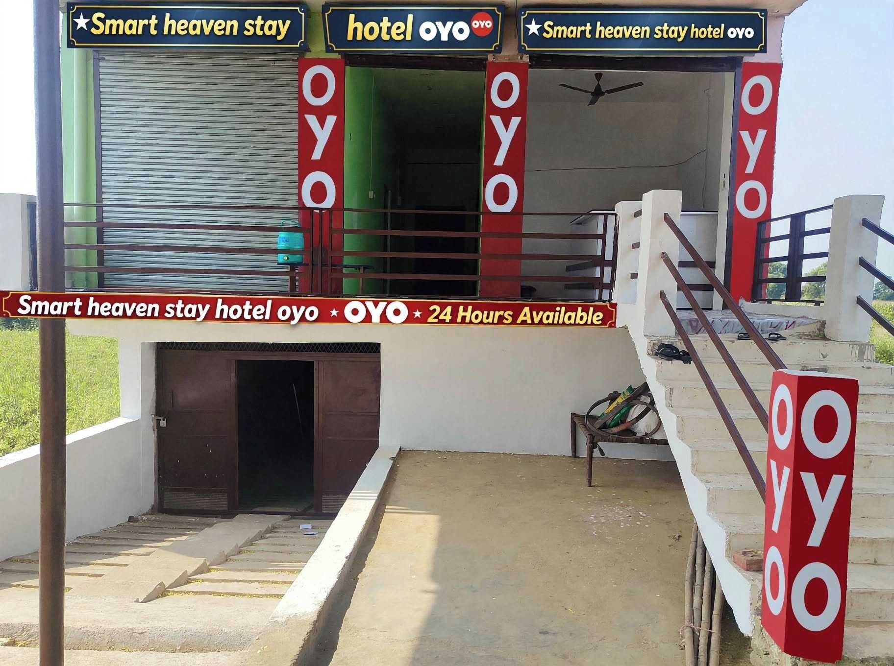 Entrada de un hotel con un letrero que indica 'Smart heaven stay hotel oyo' y 'Disponible las 24 horas'.